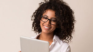 Happy-businesswoman-using-tablet-over-light-background - 1