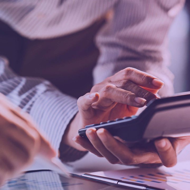 Imagem de mãos numa calculadora a analisar dados.