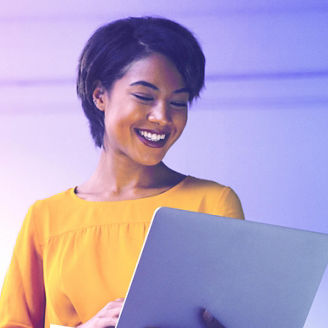 Woman smiling while looking at a tablet by a window.