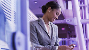 Woman sitting and chatting with colleagues in a bright office.