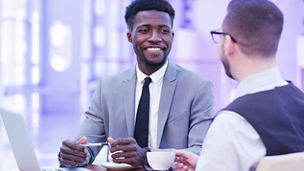 Two men in suits walking in a corporate environment.
