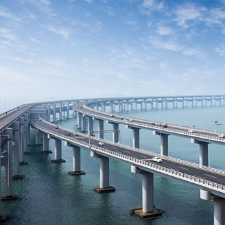 A long suspension bridge stretching over a calm, wide river.