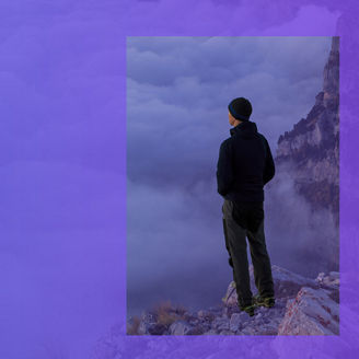 man looking over the cloud on top of a mountain