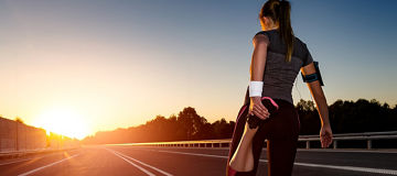 Woman stretching getting ready to run at sunset