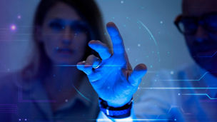 A man touching a transparent screen next to a woman	
