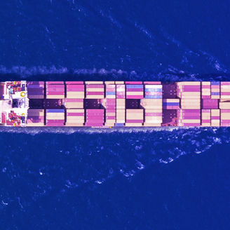 A cargo ship loaded with container sailing on a calm blue sea