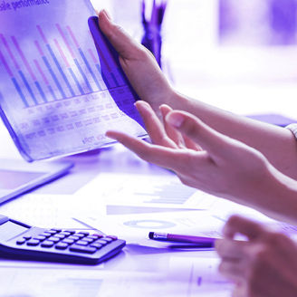 People in an office holdin a document with tables