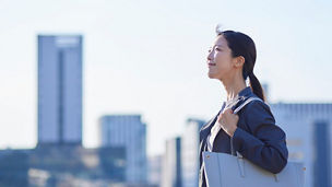 Japanese woman in front of large buildings