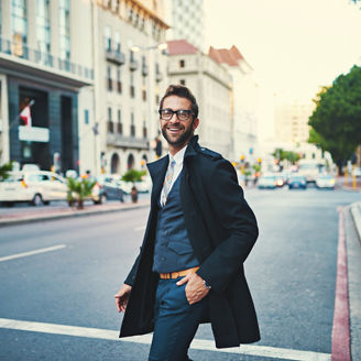 Fashion, walking and businessman in street in city with coat, glasses and classy outfit for legal career. Happy, spectacles and portrait of male law advocate commuting in town road in New York