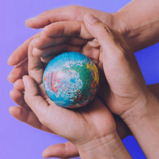 Two hands holding together a globe