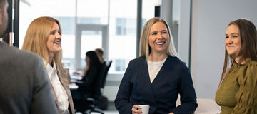 Starfsfólk KPMG á Íslandi situr brosandi í sófa að spjalla saman