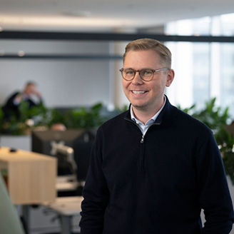 Starfsmaður KPMG stendur og brosir til samstarfskonu