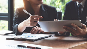 Two people looking at an iPad, discussing things and pointing