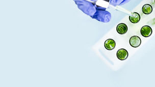 Researcher placing drops into test tubes 