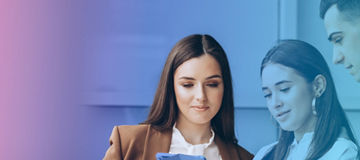 Une femme et un homme discutent tout en regardant ensemble une tablette.