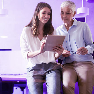 Women working together, learning on a tablet