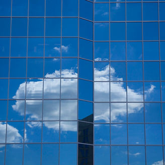Fotografía de una una nube reflejada en las ventanas de un edificio