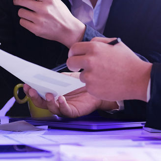 The hands of 2 people are holding paper