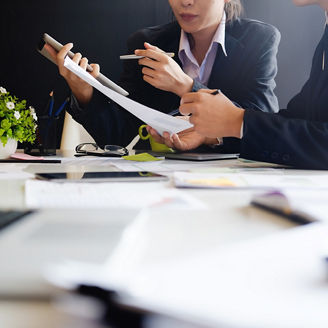 The hands of 2 people are holding paper