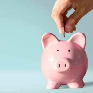 Hand putting a coin in a piggy bank