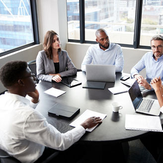 Employees sitting at a round table and discussing matters