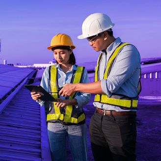 A man and a woman are holding papers and talking with a windmill in the background