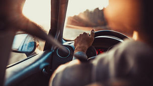 Homme tenant son volant dans sa voiture