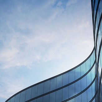 Perspective of high rise building and dark steel window system with clouds reflected on the glass.Business concept of future architecture,lookup to the angle of the building corner. 3d rendering