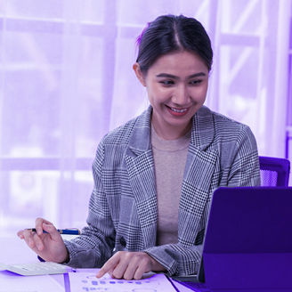 woman wearing a checkered blazer smiling while working