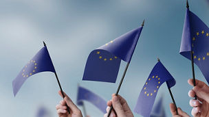 People waving with EU flags