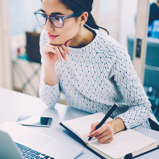 Woman working on her laptop with a notebook