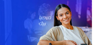 Young woman smiling and using cellphone during offline meeting in KPMG