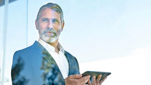 Homme d'affaires avec une tablette numérique regardant vers l'horizon