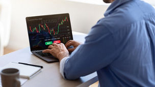 Man die de beurs checkt op laptop