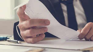 De handen van een man die een bonnetje vasthoudt.