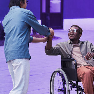 man holding hand with a person in a wheelchair