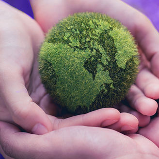 Earth shaped in green hold by hands