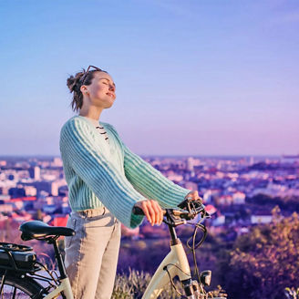 Young woman enjoying the view next to her bicycle