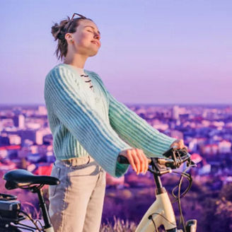 Young woman enjoying the view next to her bicycle