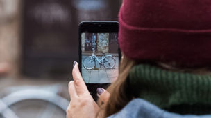 woman takes picture of bicycle with mobile phone