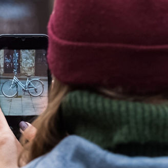 woman takes picture of bicycle with mobile phone