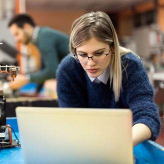 Woman working on a machine and a laptop