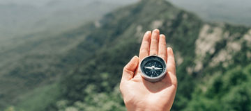 Hand holding a compass