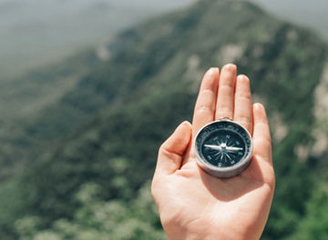 Hand holding a compass