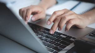 Hands are typing on the keyboard of a computer