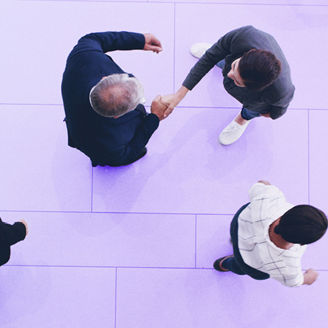 A top view on people, and two of them are shaking hands.