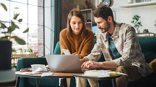 Two persons working on tax in front of a computer
