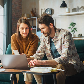 Two persons working on tax in front of a computer
