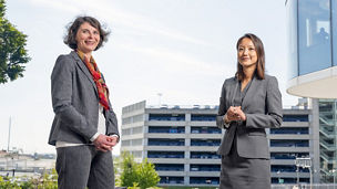 Kathy Lim and Muriel Narmon standing in front of the KPMG building