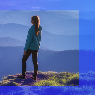 A woman is watching the forest from a mountain